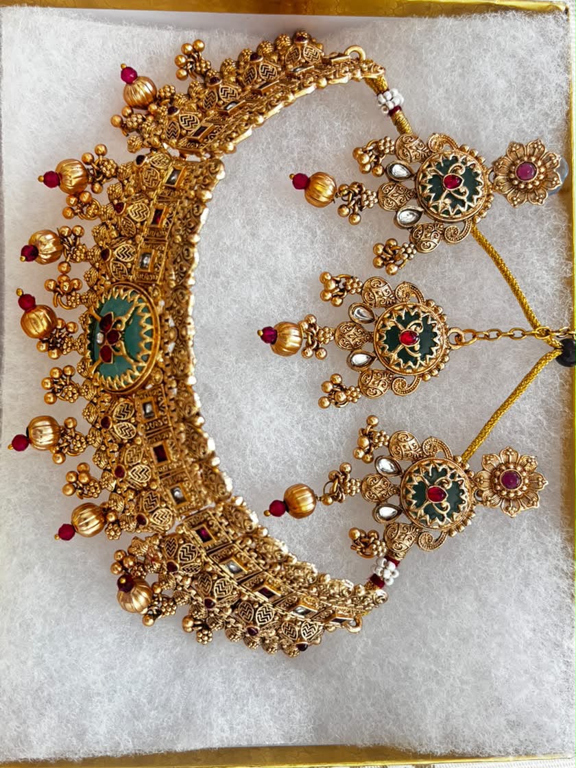 Antique gold Meenakari choker necklace set with emerald green and ruby red enamel work, matching earrings and maang tikka